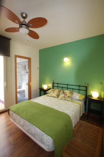 a green bedroom with a bed and a ceiling fan at Dar Saioa in Torrevieja