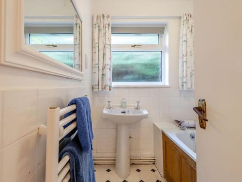 baño blanco con lavabo y ventana en Advantage Point en West Lulworth