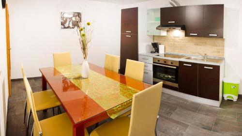 a kitchen with a wooden table and yellow chairs at Apartments Shock in Cerkno