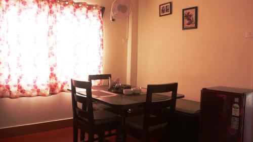 a dining room table with chairs and a window at K & K INN in Cherrapunji