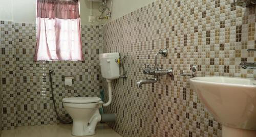 a bathroom with a toilet and a sink at K & K INN in Cherrapunji