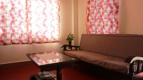 a living room with a couch and a table at K & K INN in Cherrapunji