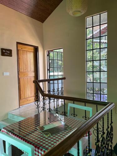 a dining room with a table and two windows at THE GINGKO EYRIE in Kalimpong
