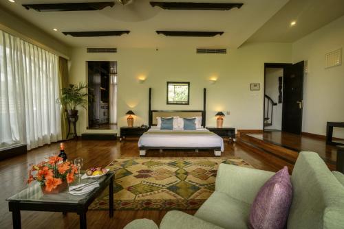 a bedroom with a bed and a couch and a table at Gokarna Forest Resort Kathmandu in Kathmandu