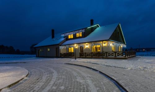 a house with christmas lights on it at night at Sodyba Ignė in Druskininkai