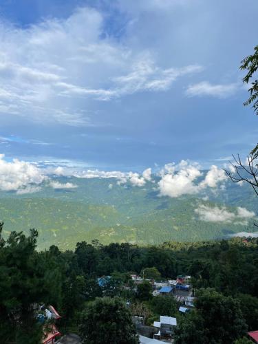 a view of a city with trees and clouds at THE GINGKO EYRIE in Kalimpong