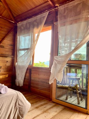 a bedroom with a window in a log cabin at CABAÑA LOS NOGALES in San Agustín