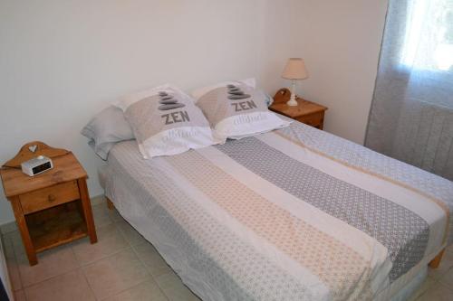 a bedroom with a bed with two pillows on it at Joli appartement au calme entre Nîmes et Avignon in Meynes