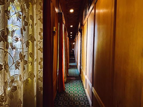 a corridor of a train with a green floor at The Heritage Gemini Group of Houseboat in Srinagar