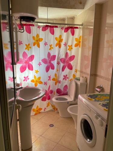 łazienka z toaletą i zasłoną prysznicową z kwiatami w obiekcie Rita's Home w Tiranie