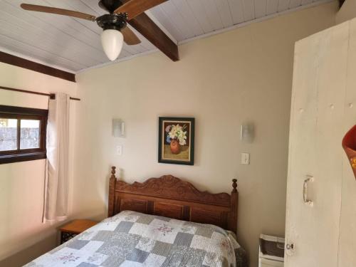 サン・ペードロ・ダ・セーハにあるPousada Lírio do Campoのベッドルーム1室(ベッド1台、シーリングファン付)
