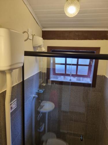 a bathroom with a toilet and a window at Pousada Lírio do Campo in São Pedro da Serra