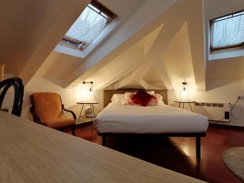 sypialnia z łóżkiem i krzesłem w pokoju w obiekcie Mercanti Attic Version w Mediolanie