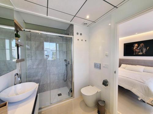 a bathroom with a sink and a shower and a bed at Premium Ferienwohnung: Allegra - Alba - Residential in Ciudad Quesada