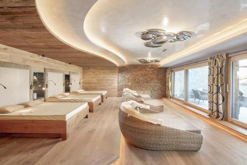 a room with four beds and a couch and a ceiling at Das Karwendel - Ihr Wellness Zuhause am Achensee in Pertisau