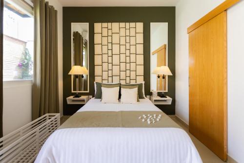 um quarto com uma cama grande e 2 candeeiros em ArcoSodi Hotel Boutique em Oaxaca City