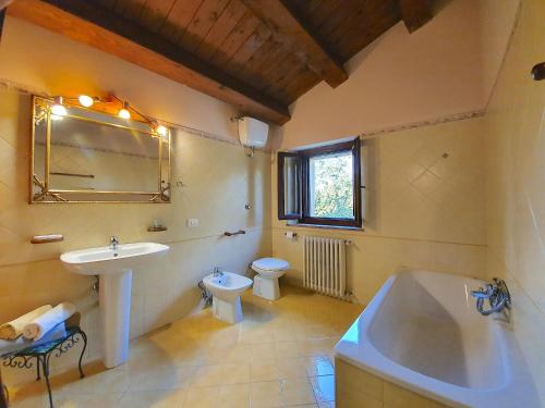 a bathroom with a sink and a tub and a toilet at Il Noceto in Monte San Giusto