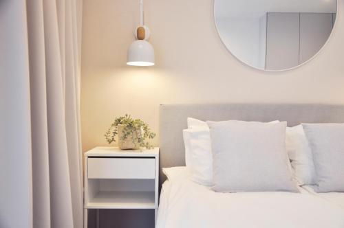 1 dormitorio con cama con almohadas blancas y espejo en Old Town Walowa, en Gdansk