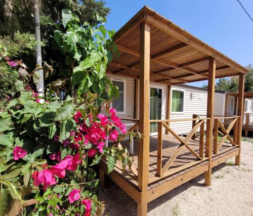 a wooden gazebo with a bunch of flowers at Camping Costa Blanca in El Campello