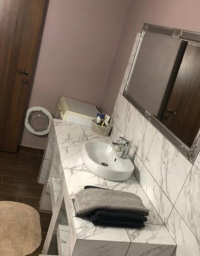 La salle de bains blanche est pourvue d'un lavabo et de toilettes. dans l'établissement Квартира в центре города, à Ouman