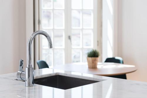 a kitchen counter with a sink and a window at Cedofeita Balcony in Porto