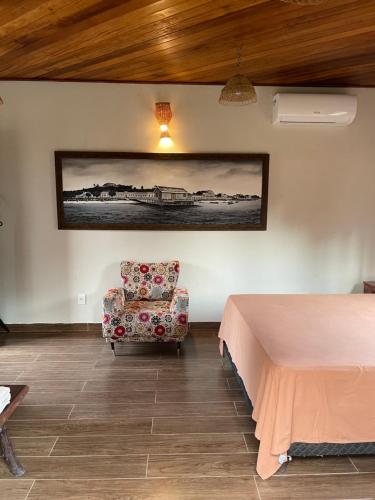 a room with a bed and a chair and a picture at Vila Ypáwa 150 m centro 30 m praia lago verde in Alter do Chao