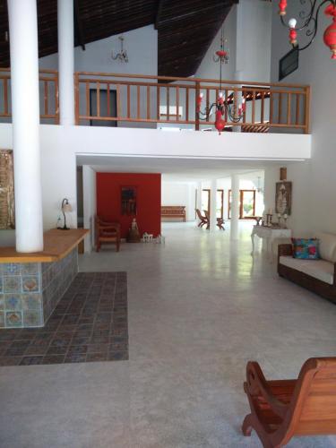 a large room with a fireplace in a building at Angá Beach Hotel in São Miguel dos Milagres