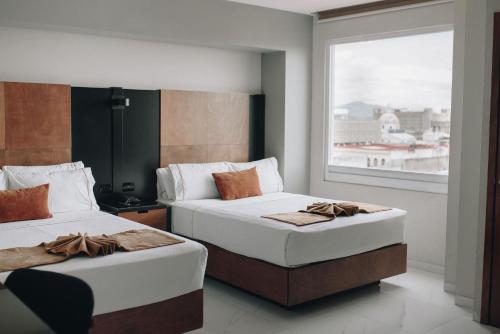 2 Betten in einem Zimmer mit Fenster in der Unterkunft Hotel Dali Plaza Ejecutivo in Guadalajara