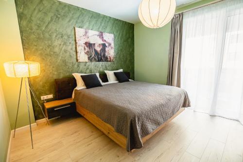 a bedroom with a bed and a green wall at Alice apartment in Sibiu