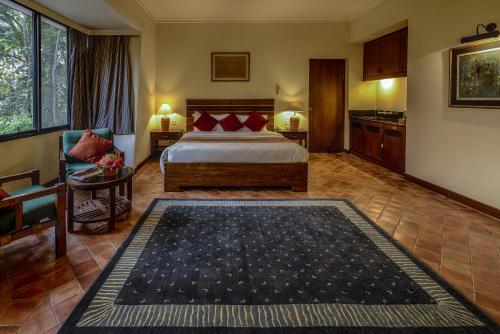 a hotel room with a bed and a kitchen at Gokarna Forest Resort Kathmandu in Kathmandu