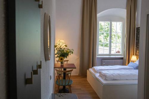 1 dormitorio con cama, mesa y ventana en Klosterwirt Polling en Polling