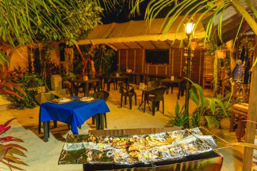 ein Restaurant mit Tischen und Stühlen und einem blauen Tisch in der Unterkunft Daisy Cottage Dhangethi in Dhangethi