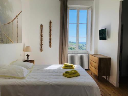 een slaapkamer met een bed met twee gele handdoeken erop bij Château Fauchey in Cardan