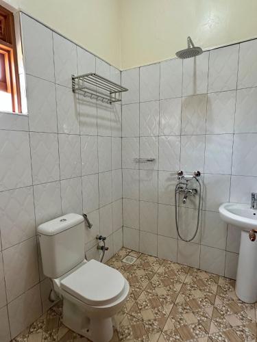 a bathroom with a toilet and a sink at Makanga Hill Suites in Kabale