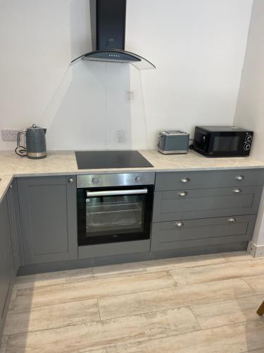 a kitchen with a counter top with a microwave at Crab Cottage in Wells next the Sea