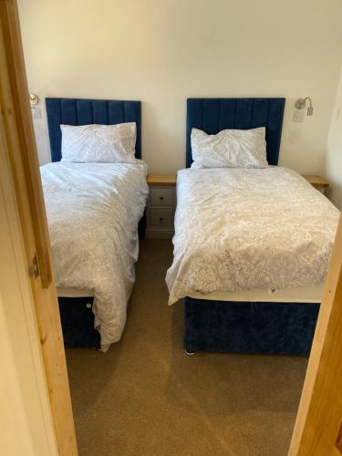 two beds sitting next to each other in a bedroom at Crab Cottage in Wells next the Sea