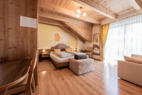 ein Schlafzimmer mit einem Bett und einem Stuhl in einem Zimmer in der Unterkunft Les Gomines BB***** in St. Vigil