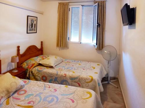 Un pat sau paturi într-o cameră la Apartamento Jardines Vía Parque