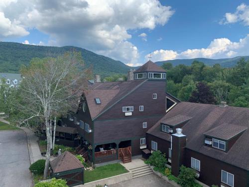 an aerial view of a large house with mountains in the background at Snowy Owl Inn in Waterville Valley