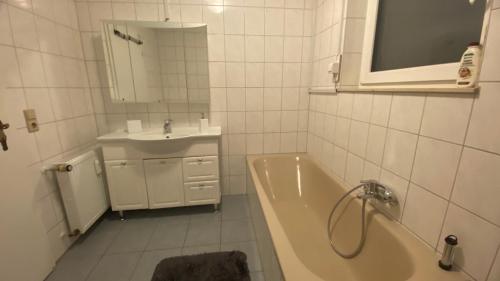 Baño blanco con bañera y lavamanos en Große Wohnung, 100 qm mit Terrasse en Alzenau in Unterfranken