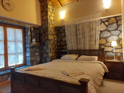 sypialnia z łóżkiem z dwoma ręcznikami w obiekcie Vitina Stone House w mieście Vytina