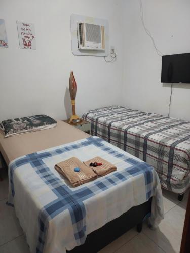 duas camas com toalhas por cima num quarto em Bonito é ser Feliz no Recife