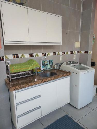 a kitchen with a sink and a washing machine at Bonito é ser Feliz in Recife