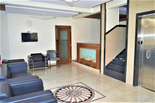 a living room with a couch and a tv at Hotel Visau,Shirdi in Shirdi