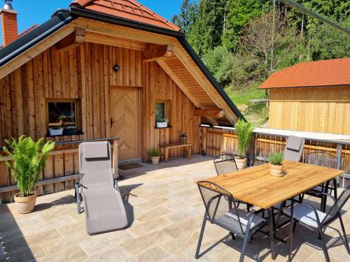 a patio with a table and chairs in front of a building at Apartma1 pri Adamu in Mislinja