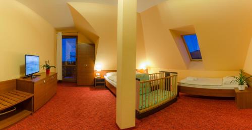 um quarto com duas camas e um berço em Pensjonat Pod5 em Karpacz