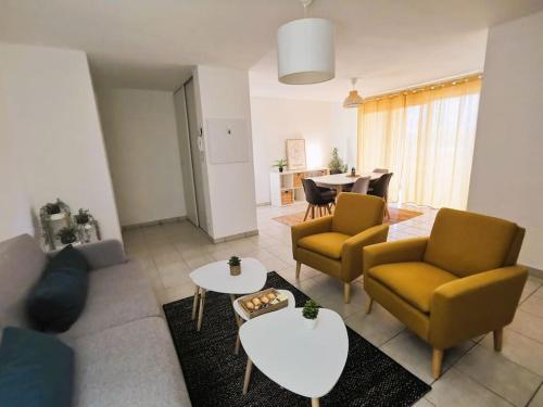 een woonkamer met 2 stoelen en een tafel bij Casteljaloux Appartement 2 chambres balcon parking résidence calme in Casteljaloux