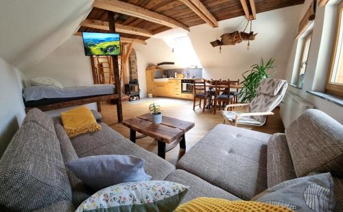 ein Wohnzimmer mit einem Sofa und einem Tisch in der Unterkunft Apartma pri Adamu in Mislinja