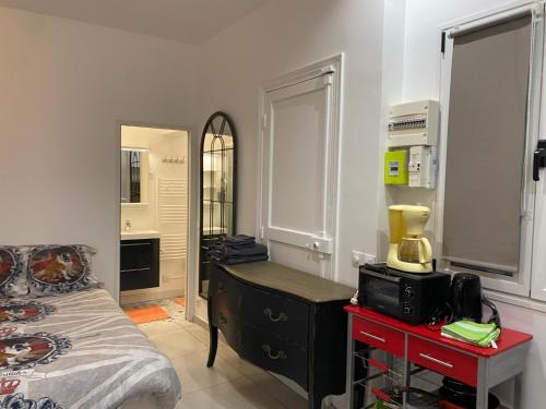 Schlafzimmer mit einem Bett, einer Kommode und einem Spiegel in der Unterkunft Hollyday Studio Paris Centre Montmarte Sacré-coeur Opera Louvre in Paris