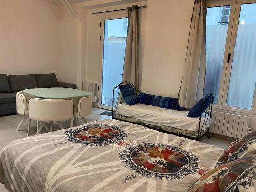 un salon avec un lit et une table dans l'établissement Studio @Paris-Centre Montmarte Sacre-coeur Opera Louvre, à Paris